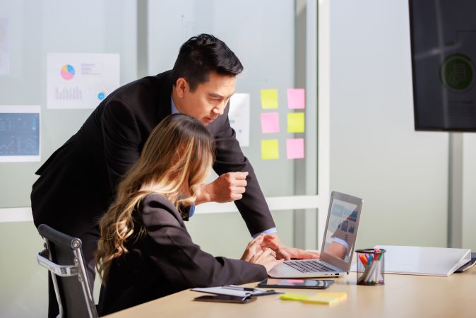 businessman mentor in formal suit coaching training helping businesswoman on laptop