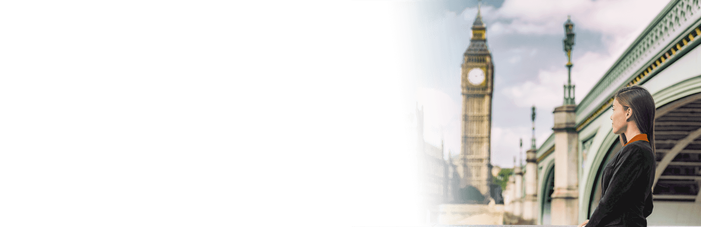 A woman standing beside a bridge with Big Ben in the background